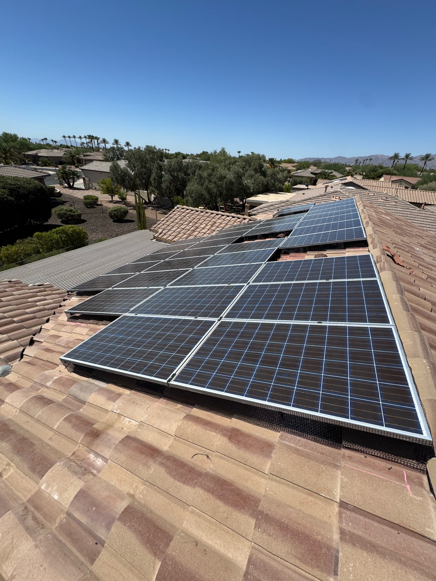 How Monsoon Prep Changes With a Solar Roof Installation in Phoenix, AZ Large solar array spanning a tile roof with clear roof areas around the panels