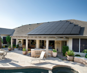 Mesa home with rooftop solar panels near a patio and pool in Arizona.