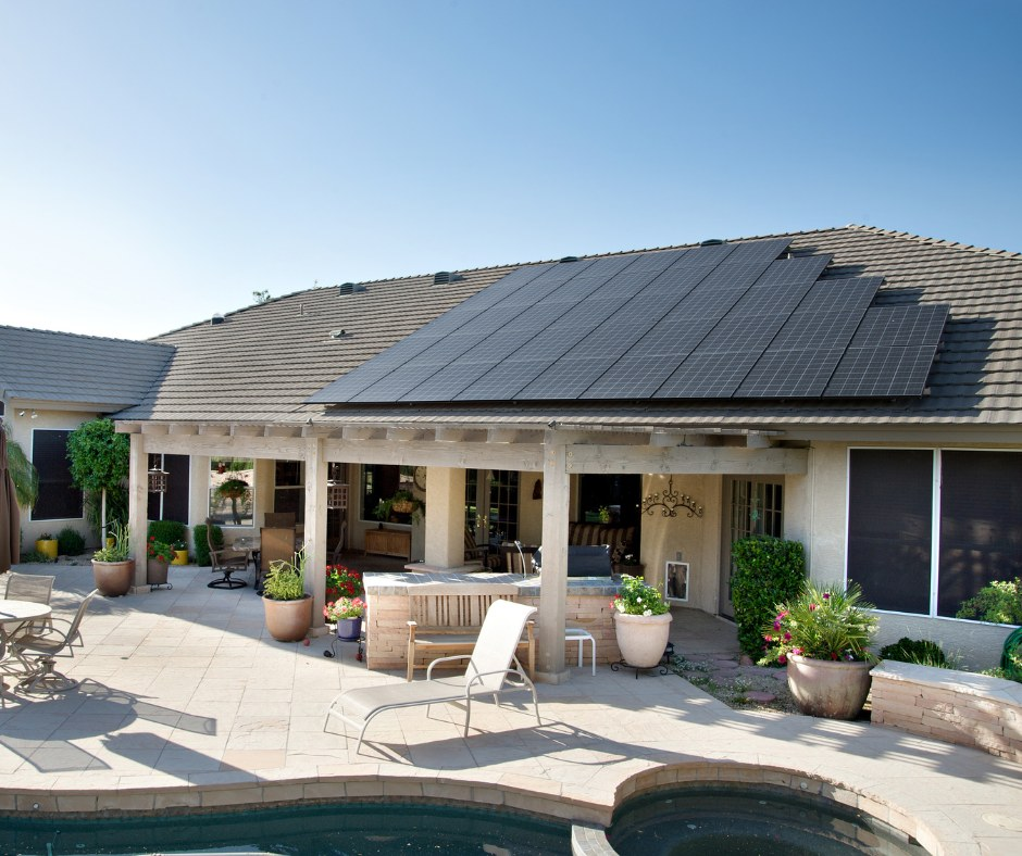 Mesa home with rooftop solar panels near a patio and pool in Arizona.