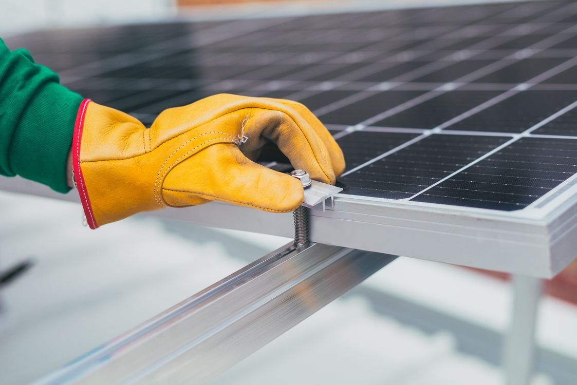  a roofing contractor installing a solar panel.