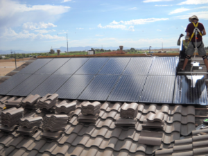 Solar technician inspecting rooftop panels during annual solar maintenance in Phoenix, AZ
