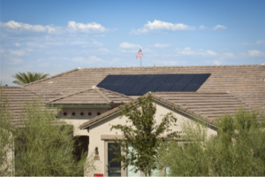 Large Arizona home with rooftop solar panels under clear desert skies