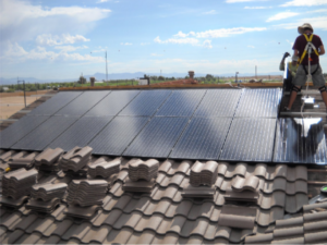 Solar installer securing mounting hardware on an Arizona tile roof
