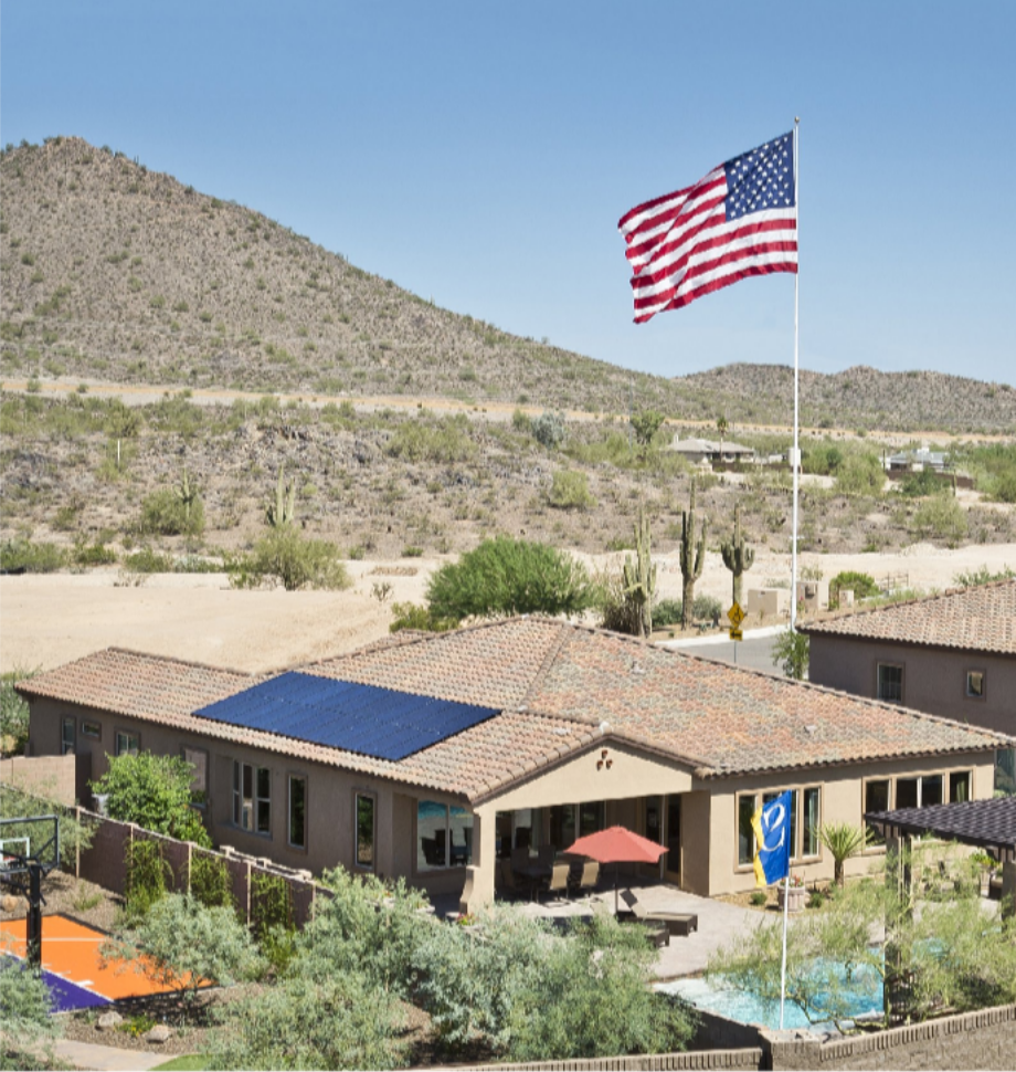 Solar for New Construction: Planning a Home Solar Installation in Phoenix, Arizona Before the Roof Goes On Arizona home with rooftop solar panels and an American flag in a desert setting